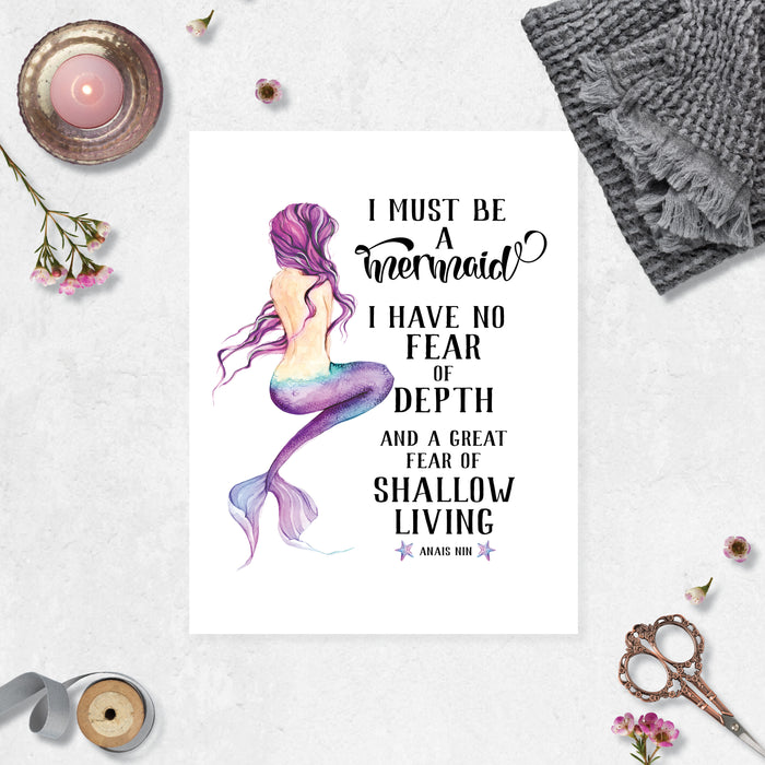 watercolor mermaid with purple hair and purple tail with the words in black I must be a mermaid I have no fear of depth and a great fear of shallow living quote by Anais Nin on matte white paper