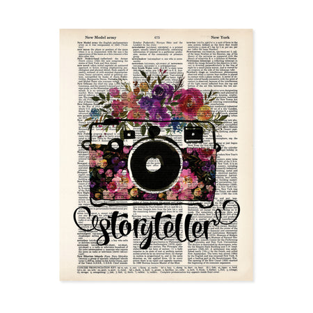 storyteller with watercolor camera and flowers in the body of the camera and on top in shades of pinks, purples, yellow, and blue with greenery printed on a dictionary page
