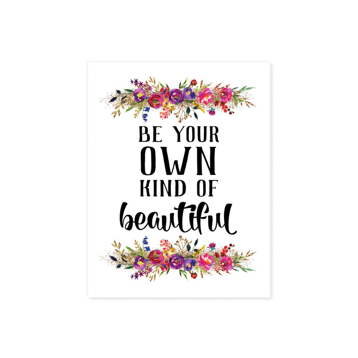 be your own kind of beautiful quote with watercolor flowers at the top and bottom of matte white paper. Flowers are pinks, purples, yellow, and golden tones