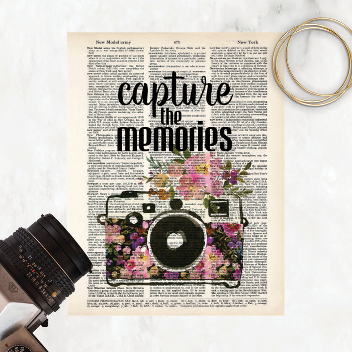 capture the memories quote and a watercolor camera decorated with watercolor flowers in pinks and purple tones on salvaged dictionary page