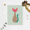 mid century modern cat styled with pink head, green tail and geometric shapes in the body, soft sage green background has shite fishes printed on matte paper