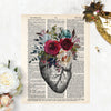 vintage etching of an anatomical heart topped with watercolor flowers in shades of reds and blues printed on a salvaged dictionary page