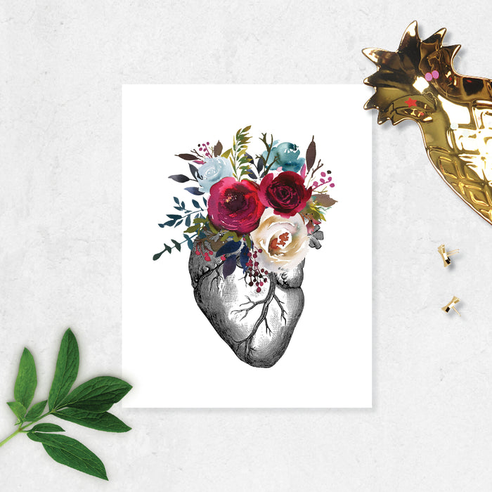 vintage etching of an anatomical heart topped with watercolor flowers in shades of reds and blues printed on matte white paper