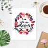 watercolor flowers wreath in pinks and deep reds surround the words I am with you always from the book of Matthew printed on matte white paper