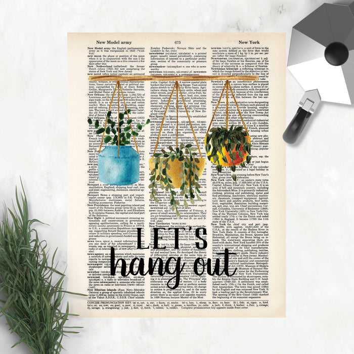 three potted plants hang from a bamboo rod above the words let's hang out in black printed on a salvaged dictionary page