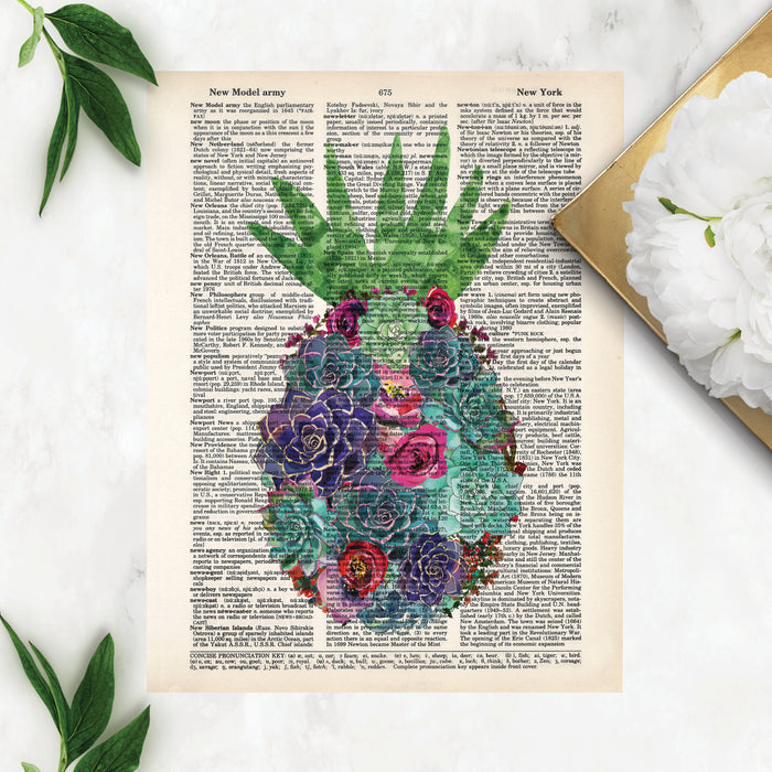 watercolor suculents in greens and purples along with pink and red flowers in the shape of a pineapple with an aloe vera at the top to be the pineapple leaves printed on a dictionary page