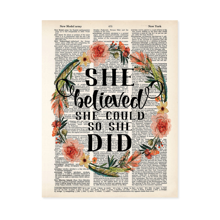she believed she could so she did in black ink surrounded by a wreath in peach tone flowers and blue green feathers and greenery printed on a dictionary page