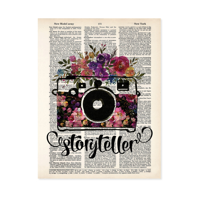 storyteller with watercolor camera and flowers in the body of the camera and on top in shades of pinks, purples, yellow, and blue with greenery printed on a dictionary page 