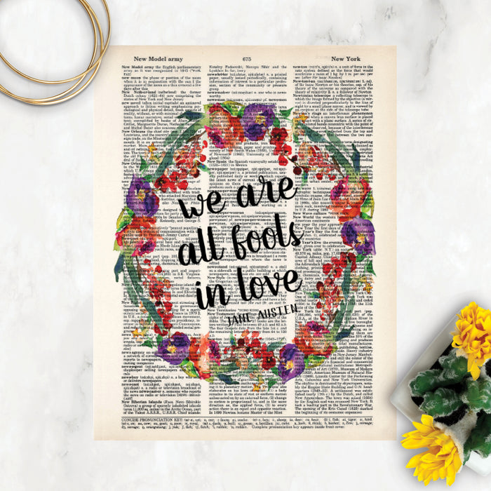 we are all fools in love Jane Austen quote surrounded by a watercolor wreath in purple, red, and green colors printed on a dictionary page