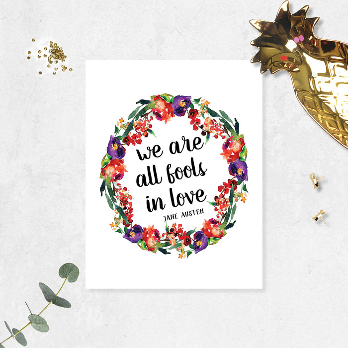 we are all fools in love Jane Austen quote surrounded by a watercolor wreath in purple, red, and green colors printed on matte white paper