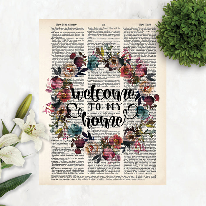 welcome to my home surrounded by a watercolor wreath in muted tones of pink, purple, blue and greenery printed on a dictionary page